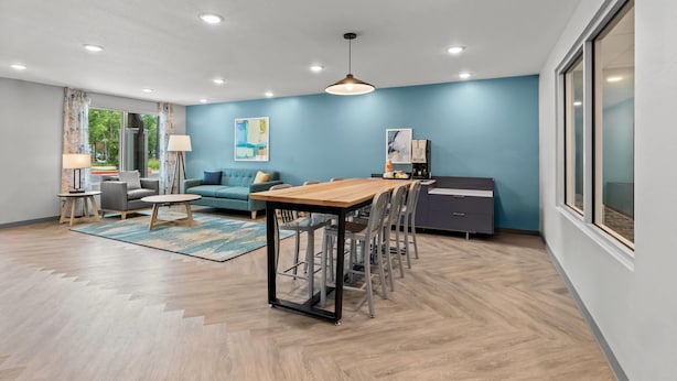 Uma sala de estar moderna com uma mesa de jantar, sofá e uma janela grande.
