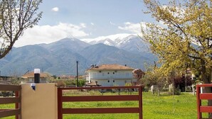 Una entrada cerrada con vista a un edificio y montañas al fondo.
