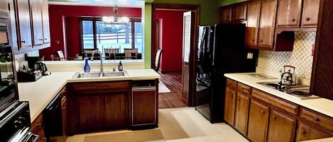 Una cocina con armarios de madera, una isla central y vista a un comedor.