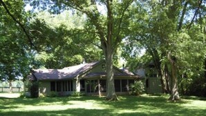 A house with a large lawn and trees. - Large private home in gated horse farm in the heart of horse country! (Lexington)
