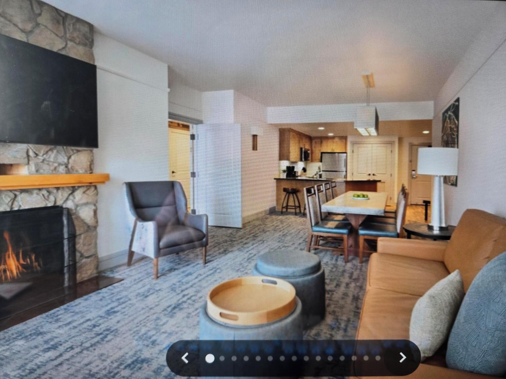 Una sala de estar moderna con chimenea, un comedor y una cocina.