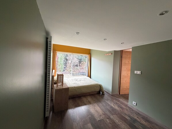 Une chambre à coucher avec un lit, une fenêtre et un bureau en bois.