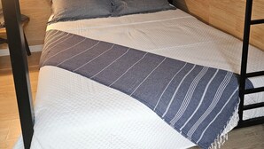 Una cama litera con cabecera de madera y colcha acolchada.