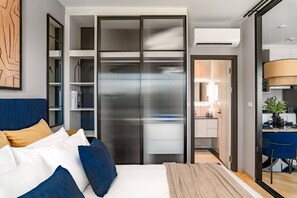 A modern bedroom with a bed, a wardrobe, and a bathroom visible through an open door. - Suite Palma 1br the Title Ibg legendary bang tao (Choeng Thale)