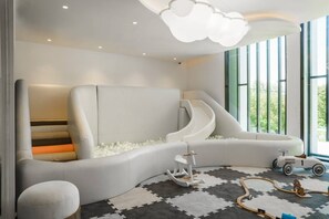 A modern playroom with a slide, a ball pit, and a toy train set. - Suite Valencia 2br the Title Legendary bangtao (Choeng Thale)