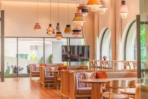 Een modern interieur met zitmogelijkheden, een televisie en grote ramen.