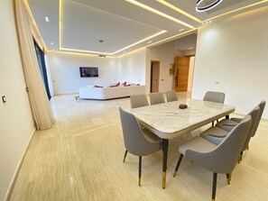A modern dining area with a marble table and grey upholstered chairs. - Villa Prestige Piscine - Argan Golf gym (Marrakech)