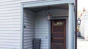 Un edificio bianco con una porta in legno con la scritta 