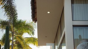 A modern building with a stone staircase leading to a glass door, surrounded by palm trees. - Mr. W | Sophisticated Apartment in Torre Marsai (Punta Negra)