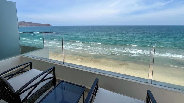 A balcony with a view of the ocean, a glass railing, and a seating area with chairs and a table. - Mr. W | Sophisticated Apartment in Torre Marsai (Punta Negra)