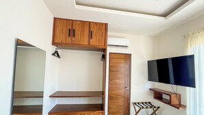 Ein Zimmer mit eingebauten Holzschränken, einem Flachbildfernseher und einem Deckenventilator.