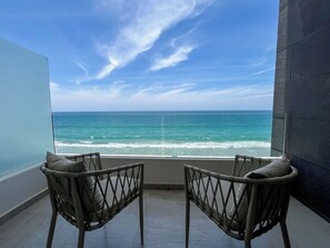 A balcony with two chairs facing a view of the ocean. - Mr. W | Charming Marsai Tower apartment (Punta Negra)