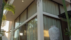 A modern building with a stone staircase leading to a glass entrance, surrounded by tropical plants. - Mr. W | Modern and Stylish 1BR in Torre Marsai (Punta Negra)