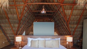 A spacious bedroom with a large bed, wooden headboard, and two bedside lamps.