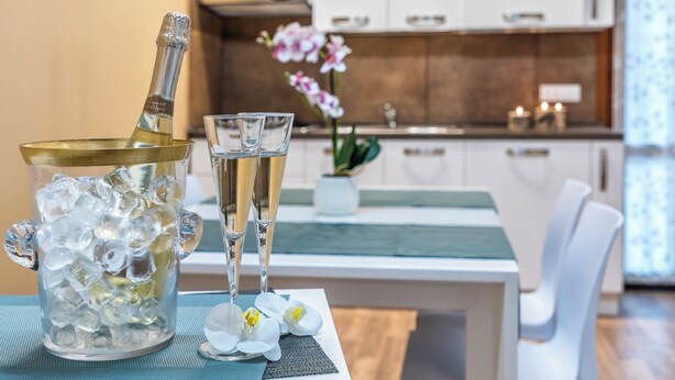 A kitchen with white cabinets, a countertop, and a vase with flowers. - Sweet Dream Apartment 15 min to Venice · Bus 24/7 (Venezia)