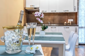 A kitchen with white cabinets, a countertop, and a vase with flowers. - Sweet Dream Apartment 15 min to Venice · Bus 24/7 (Venezia)