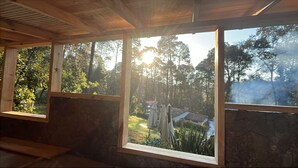A room with large windows, wooden beams, and a stone wall. - Cozy 4-bedroom cabin in perfect harmony in Rancho ojo de luz cabañas de aventura (Rancho Avándaro Country Club)