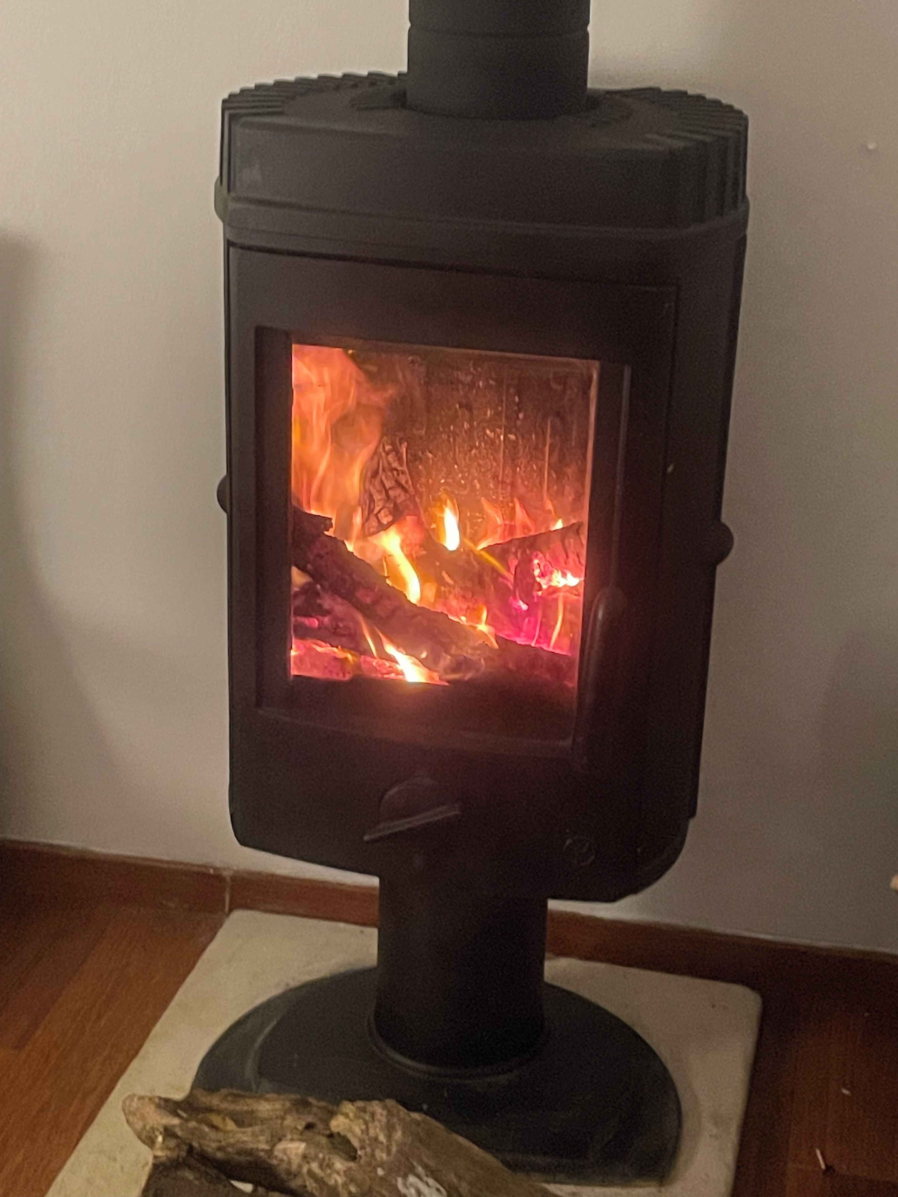 A wood-burning stove with a visible fire inside.