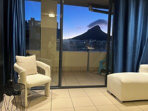 Ein Balkon mit Blick auf einen Berg und Stadtlichter.