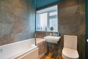 Ein Badezimmer mit Badewanne, Waschbecken und Toilette.