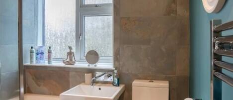 A modern bathroom with a bathtub, a sink, and a toilet.