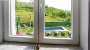 Ein Zimmer mit Blick auf einen Pool und eine Rasenfläche.