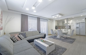 A modern living room with a sofa, coffee table, and dining area with chairs. - Beautiful home in Zagreb (Zagreb)