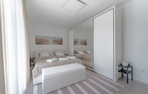 A modern bedroom with a bed, bedside tables, a bench, a mirror, and artwork on the wall. - Beautiful home in Zagreb (Zagreb)
