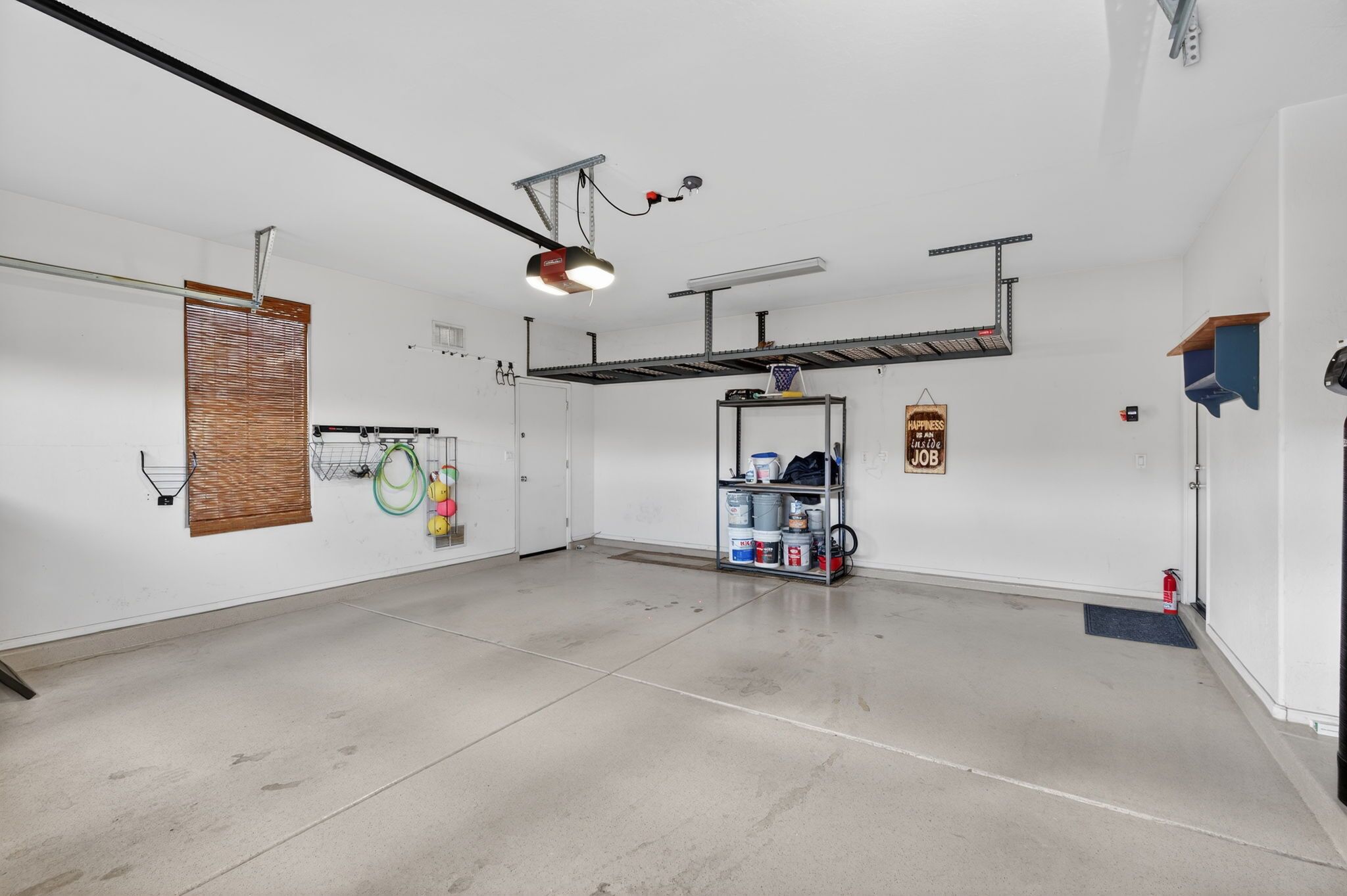 A spacious garage with a concrete floor, a workbench, and a ceiling-mounted light fixture.