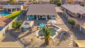 Um imóvel residencial com piscina, área de estar no pátio e espaço coberto ao ar livre.