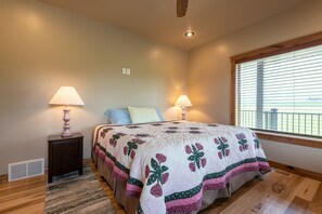A bedroom with a large bed, two bedside lamps, a window with blinds, and a ceiling fan. - Teton View Retreat- Hot Tub - Game Room - Fire Pit (Alta)