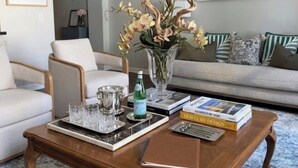 A living room with a coffee table, chairs, a sofa, a vase with flowers, and books. - 2BR Executive Suite Downtown Cleveland (Cleveland)