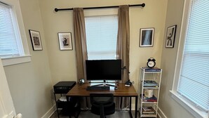 A compact office space with a desk, chair, computer, and bookshelf.
