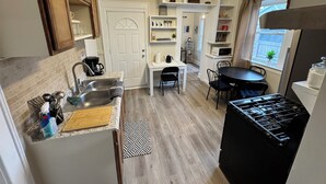 A compact kitchen with a sink, stove, and dining area.