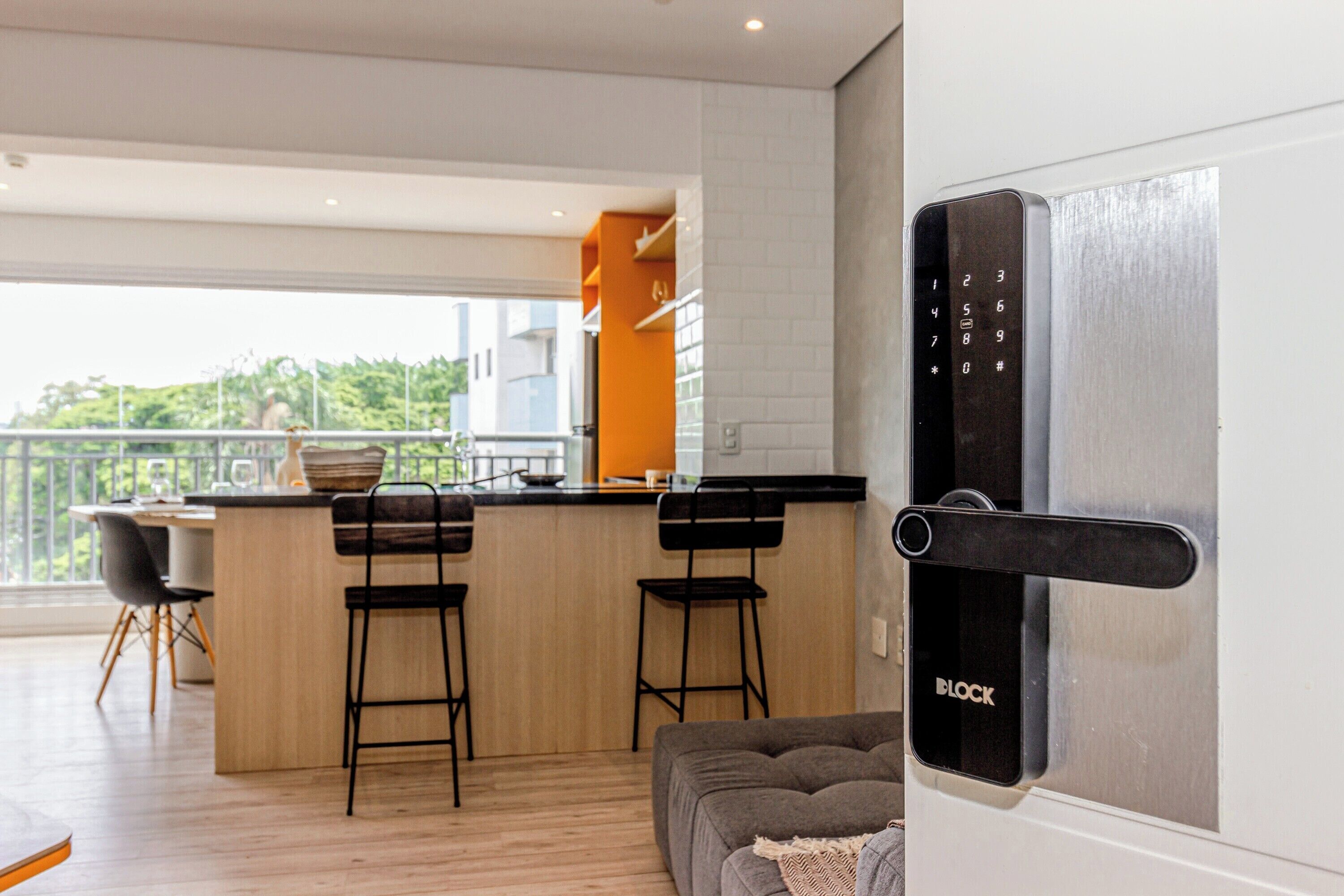 A modern kitchen with a bar area, a dining set, and a sofa.