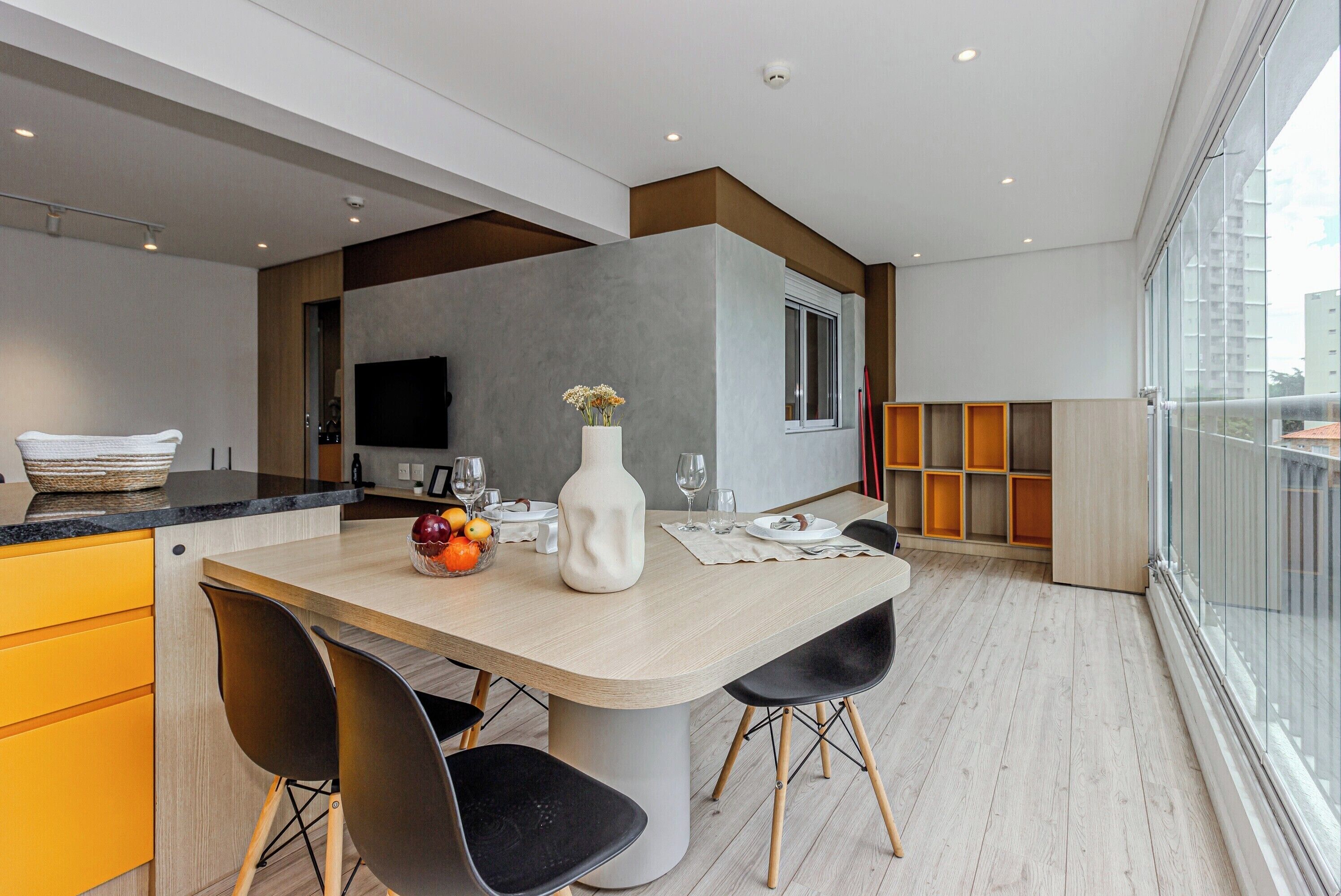 Una cocina moderna con una isla grande, armarios de madera y un televisor integrado.
