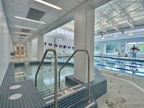 An indoor swimming pool with clear lanes, a lifeguard stand, and a tiled floor. - 5 Bedroom Beach House w/ Pool, Gym & Tennis Access (Bethany Beach)