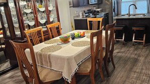 A dining area with a wooden table, chairs, and a buffet cabinet. - Charming Home in La Vergne | Chill and Relax (La Vergne)