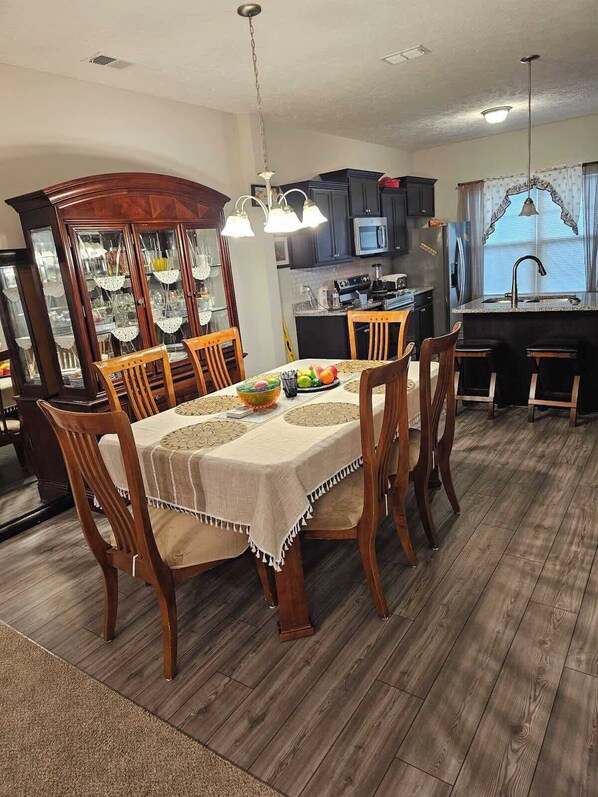 A dining area with a wooden table, chairs, and a buffet cabinet.