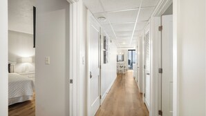 En hall med en säng på vänster sida, en matplats i mitten och utsikt över utomhusmiljön genom ett fönster.