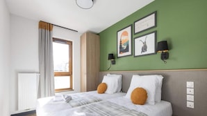 A double bed with white linens, two pillows, a plaid blanket, and a bedside table with a lamp. - Wellness Refuge Near the Sauna way (La Salle-les-Alpes)