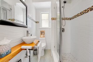 A bathroom with a white sink, toilet, and shower. - Sunny Art Deco Studio – Walk to Conv Ctr & DTLB (Long Beach)