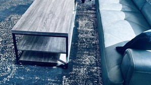Un soggiorno moderno con un divano grigio, un tavolino da caffè e un'area pranzo con tavolo e sedie.