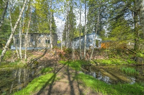 A house surrounded by trees and a pond.