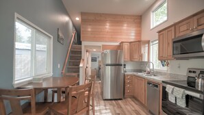 A modern kitchen with wooden cabinets, a stainless steel refrigerator, and a built-in oven.