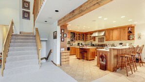 A spacious kitchen with wooden cabinets, a large island, and a built-in stove. - 3 Mi to Vail Village: Classic Estate w/ Hot Tub! (Vail)