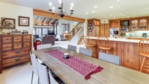 A spacious kitchen with wooden cabinets, a dining area with a wooden table, and a staircase leading to an upper level. - 3 Mi to Vail Village: Classic Estate w/ Hot Tub! (Vail)