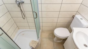 A bathroom with a shower, toilet, and sink.