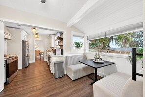 A modern kitchen with a dining area, a bench, and a view of the outdoors. - Luxury Home on Dora Lake – 2 Min to Downtown Mount Dora (Mount Dora)