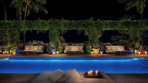 Ein Poolbereich mit Pool, Liegestühlen und Topfpflanzen.